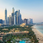 Aerial view of Jumeirah area with luxury beachfront, modern skyscrapers, and lush gardens in Dubai, showcasing Jumeirah Garden plots for sale near the coast.