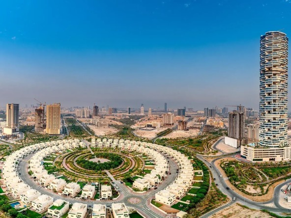 Aerial view of a circular villa community near high-rises and mixed use plots Dubai.